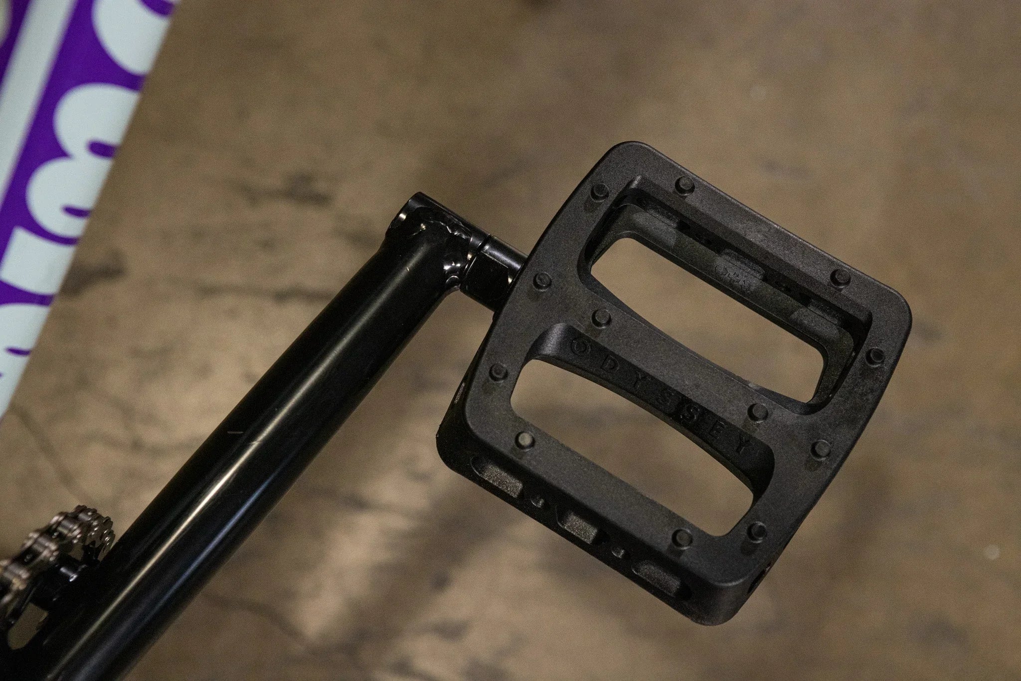 Pédale de BMX noire Odyssey en gros plan sur un cadre de vélo
