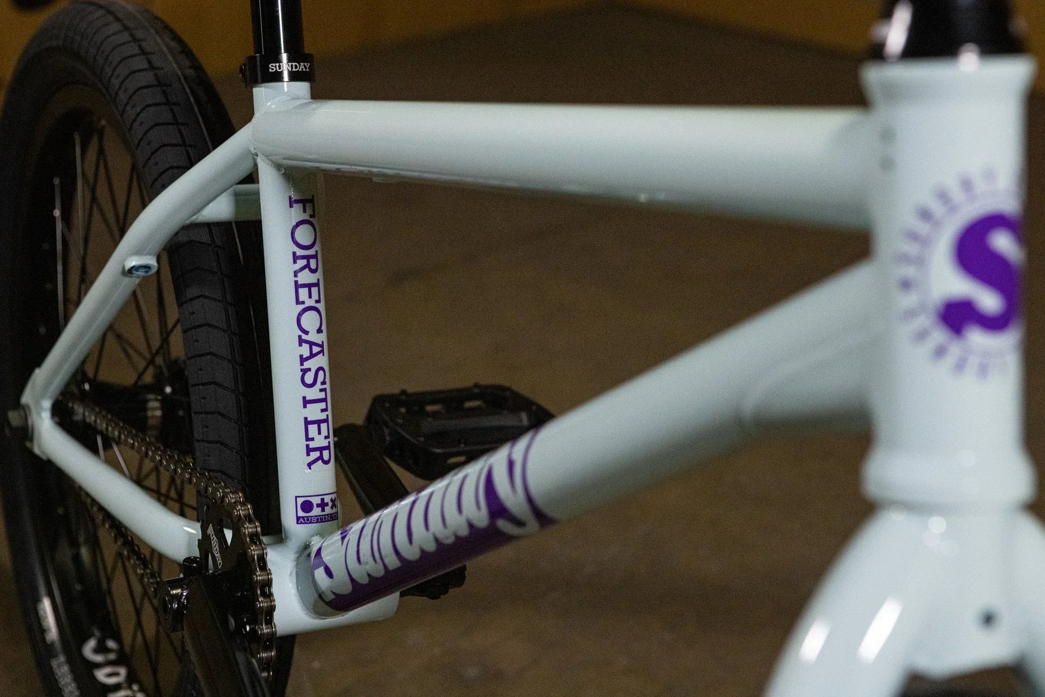 Détail du cadre blanc d'un vélo BMX Sunday Forecaster avec logos violets.