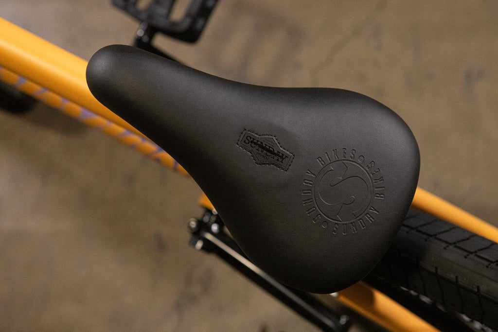 Selle de vélo BMX noire marque Sunday sur cadre jaune