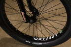 Gros plan d'une roue de vélo BMX avec pneu Odyssey et fourche Sunday noire.