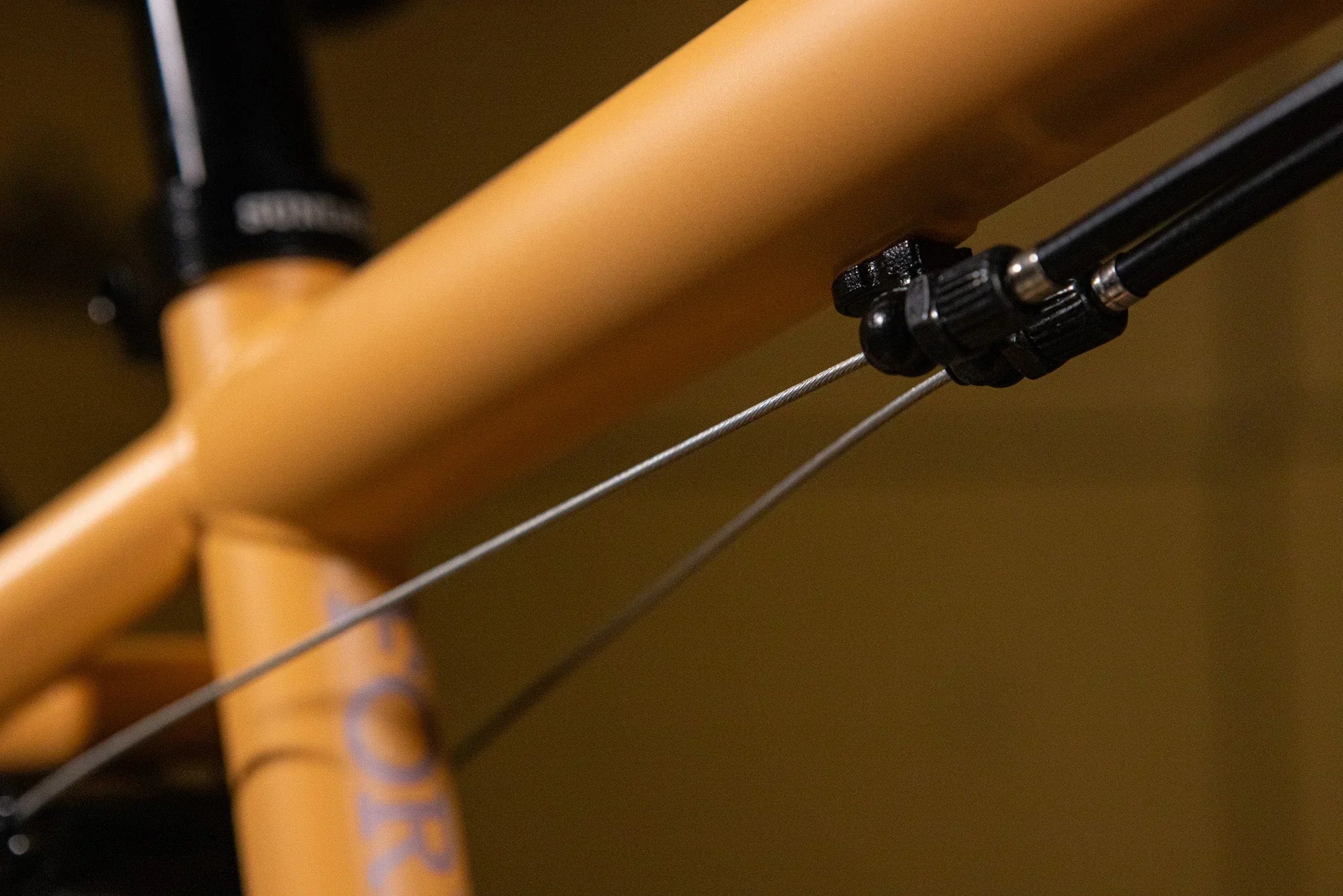 Gros plan du câble de frein sur le cadre jaune d'un vélo BMX