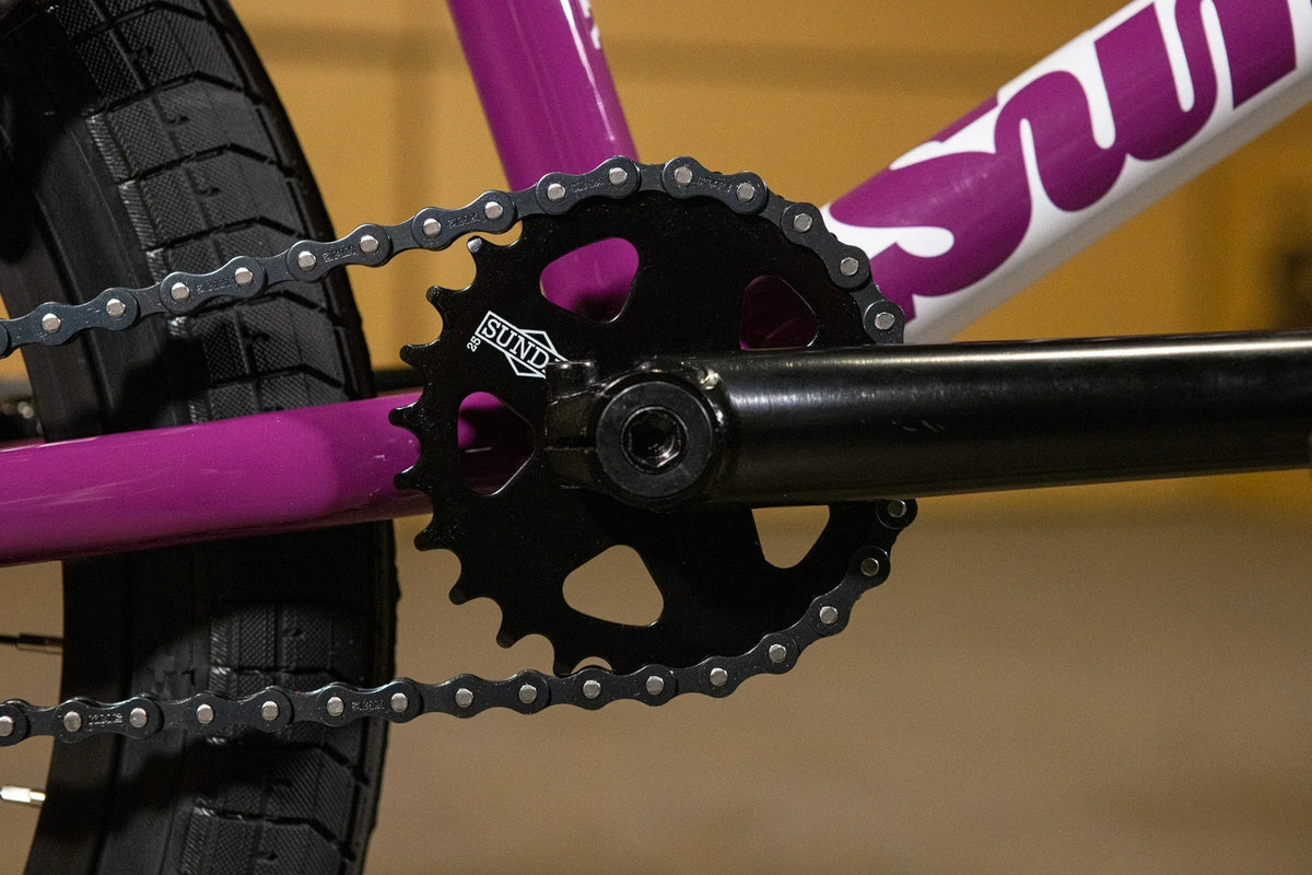 Gros plan du plateau Sund et de la chaîne sur un cadre de vélo BMX violet