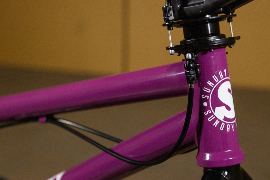 Gros plan du cadre violet d'un vélo BMX Sunday avec détails du jeu de direction.
