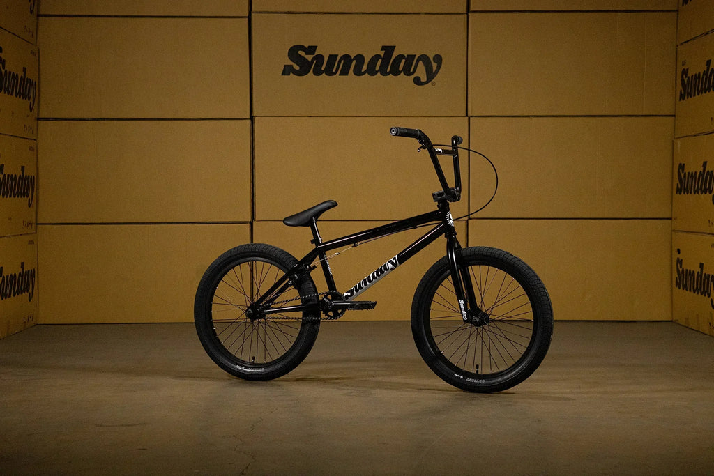 Vélo BMX Sunday noir sur fond de cartons marrons