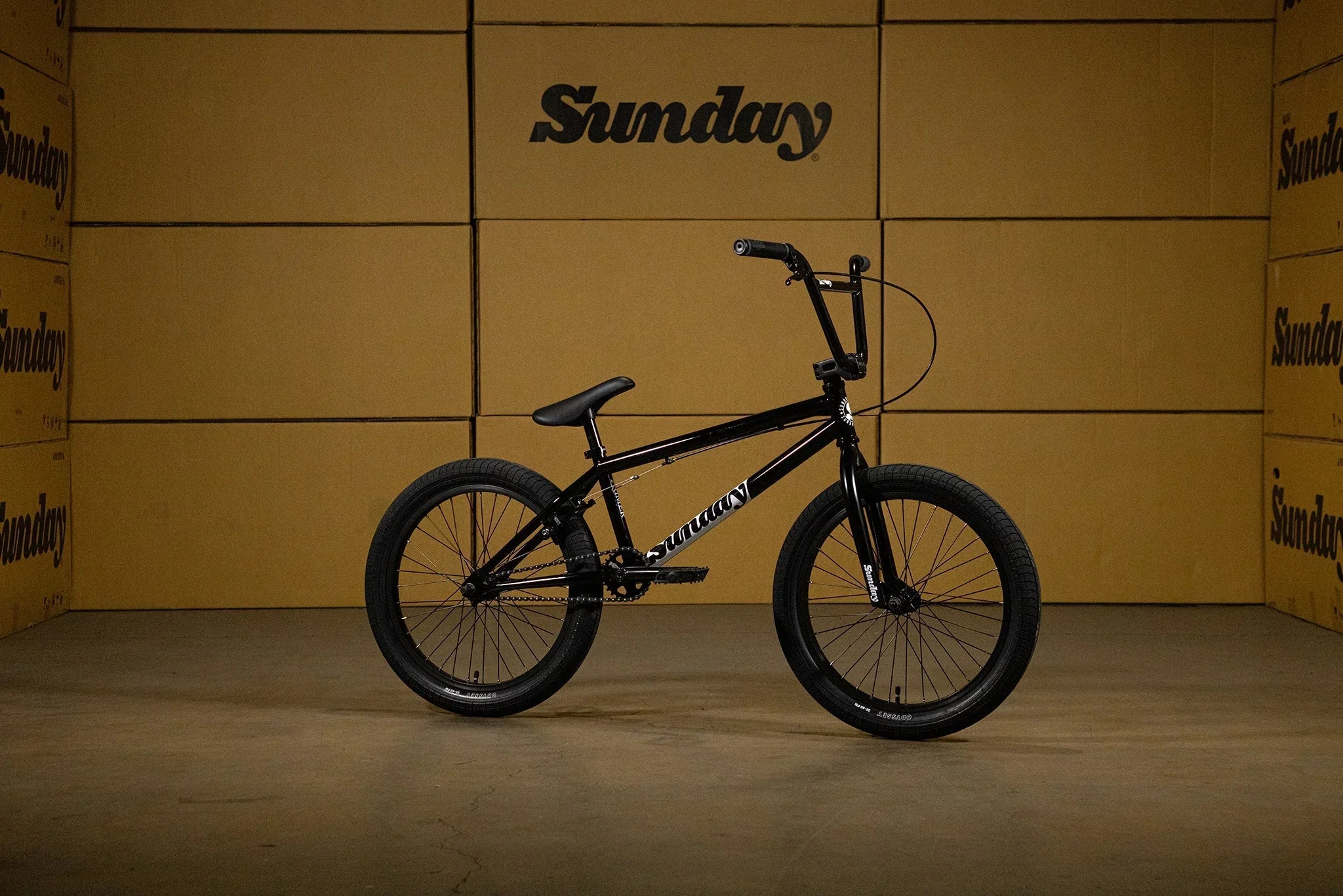 Vélo BMX Sunday noir sur fond de cartons marrons