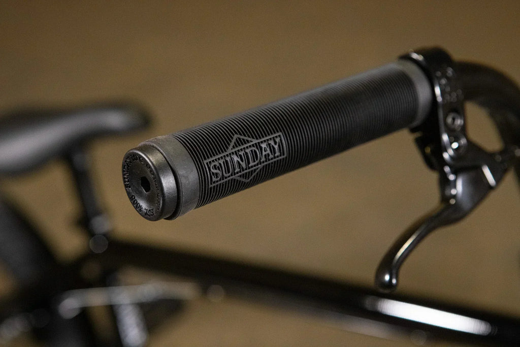 Gros plan d'une poignée de guidon de vélo BMX noire de marque Sunday