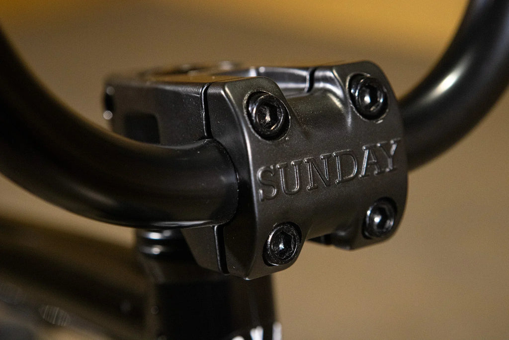 Gros plan d'une potence de vélo BMX noire de marque Sunday