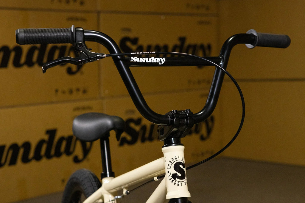 Gros plan sur le guidon noir d'un vélo BMX Sunday avec poignées et leviers de frein.