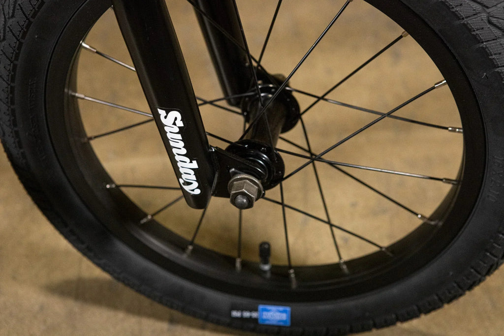 Gros plan d'une roue avant de vélo BMX avec fourche noire marquée Sunday