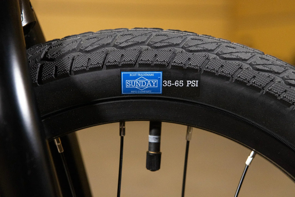 Gros plan d'un pneu de vélo BMX Sunday avec indication de pression 35-65 PSI