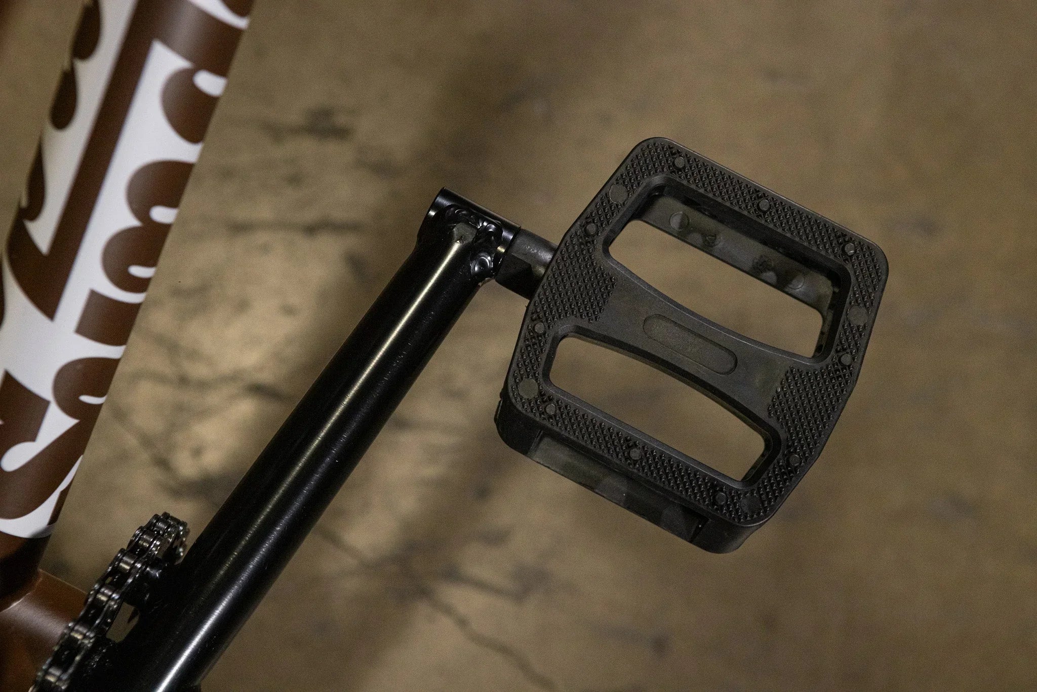 Gros plan d'une pédale plate en nylon noir sur un vélo BMX