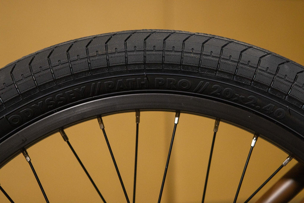 Gros plan d'un pneu BMX Odyssey Path Pro 20x2.40 noir avec sculptures