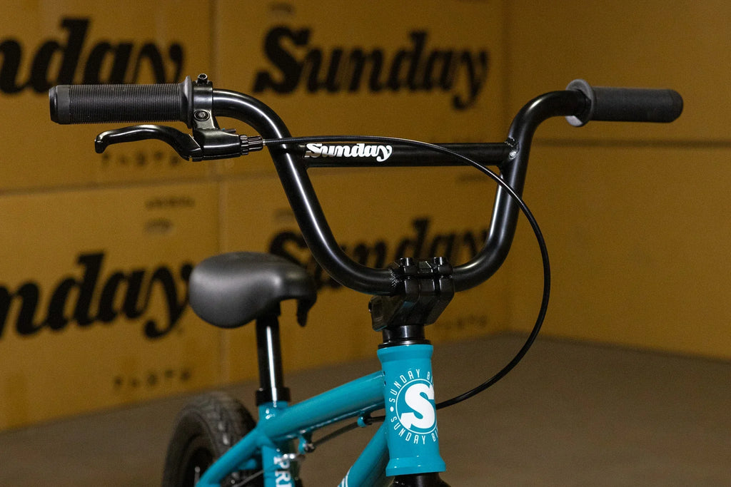 Gros plan du guidon et du cadre bleu d'un vélo BMX Sunday