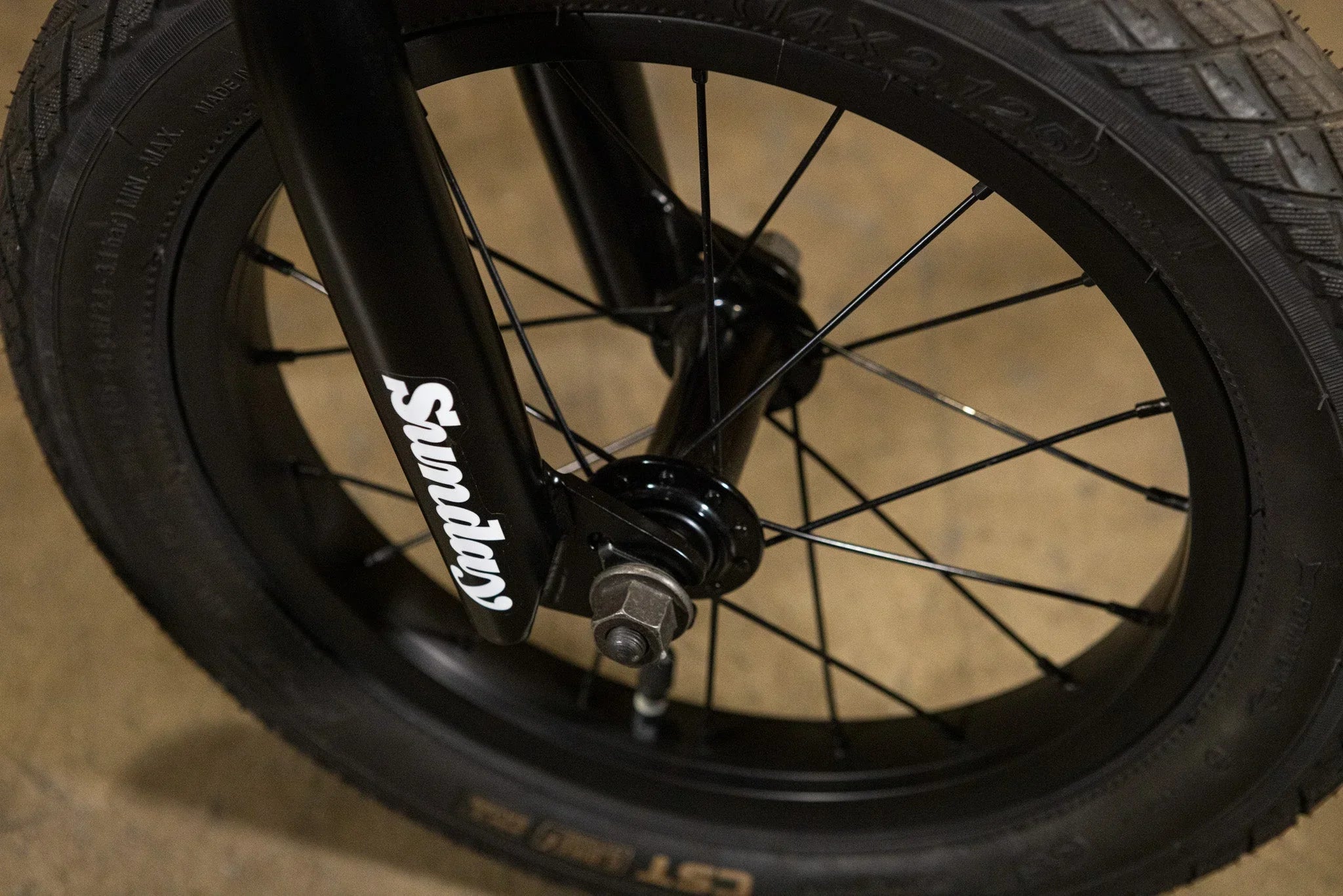 Gros plan d'une roue et d'une fourche de vélo BMX noire avec logo Sunday
