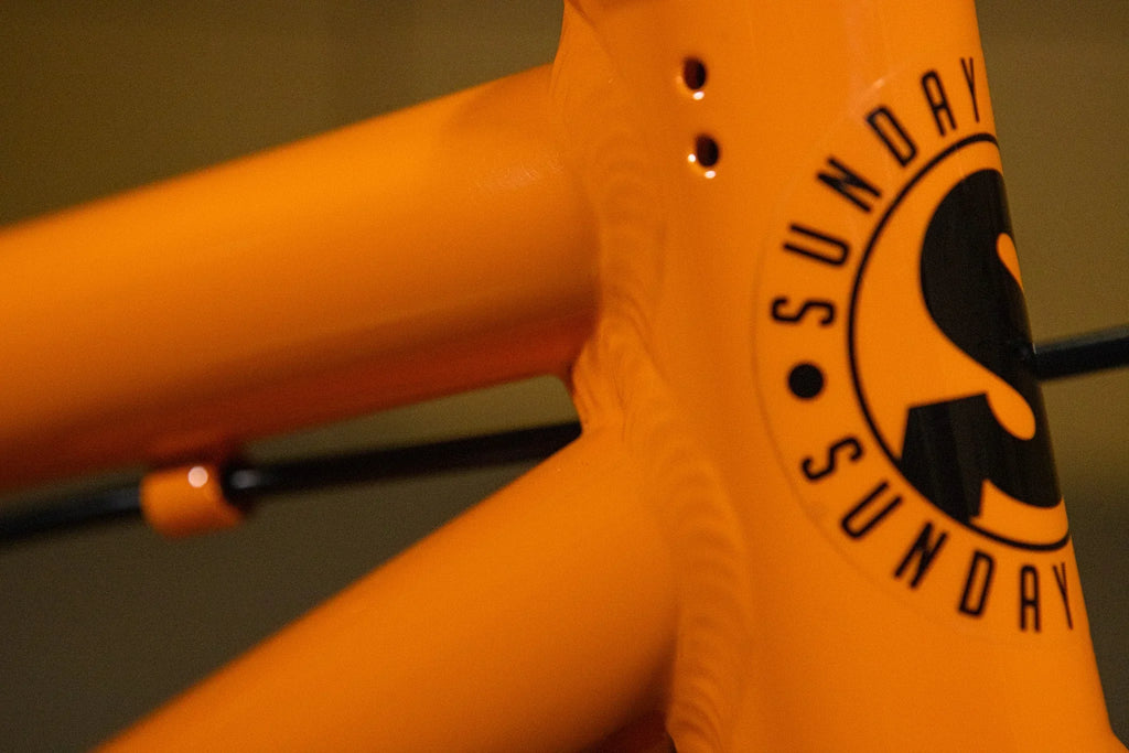 Gros plan d'un cadre de vélo BMX orange avec logo Sunday