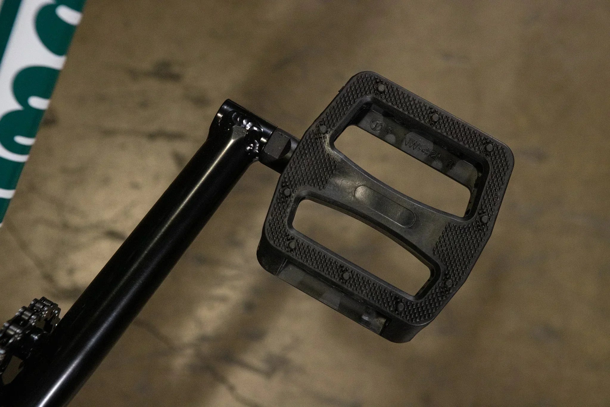 Gros plan d'une pédale de BMX noire en plastique avec surface antidérapante