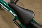 Gros plan d'une selle de vélo BMX noire avec logo embossé sur cadre vert