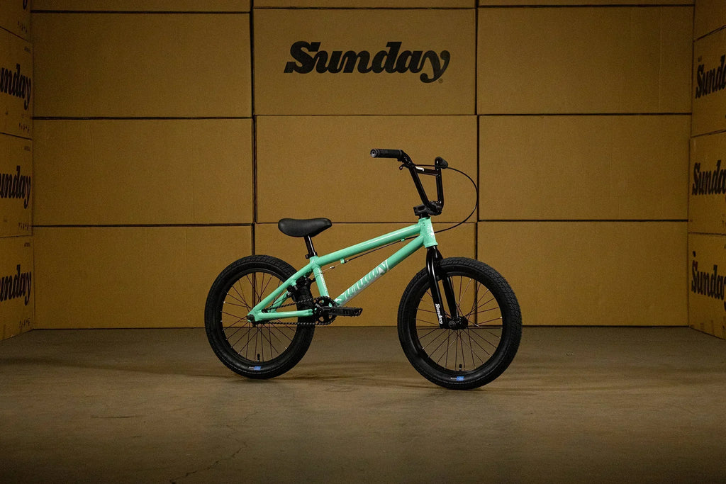 Vélo BMX Sunday vert menthe sur fond de cartons bruns