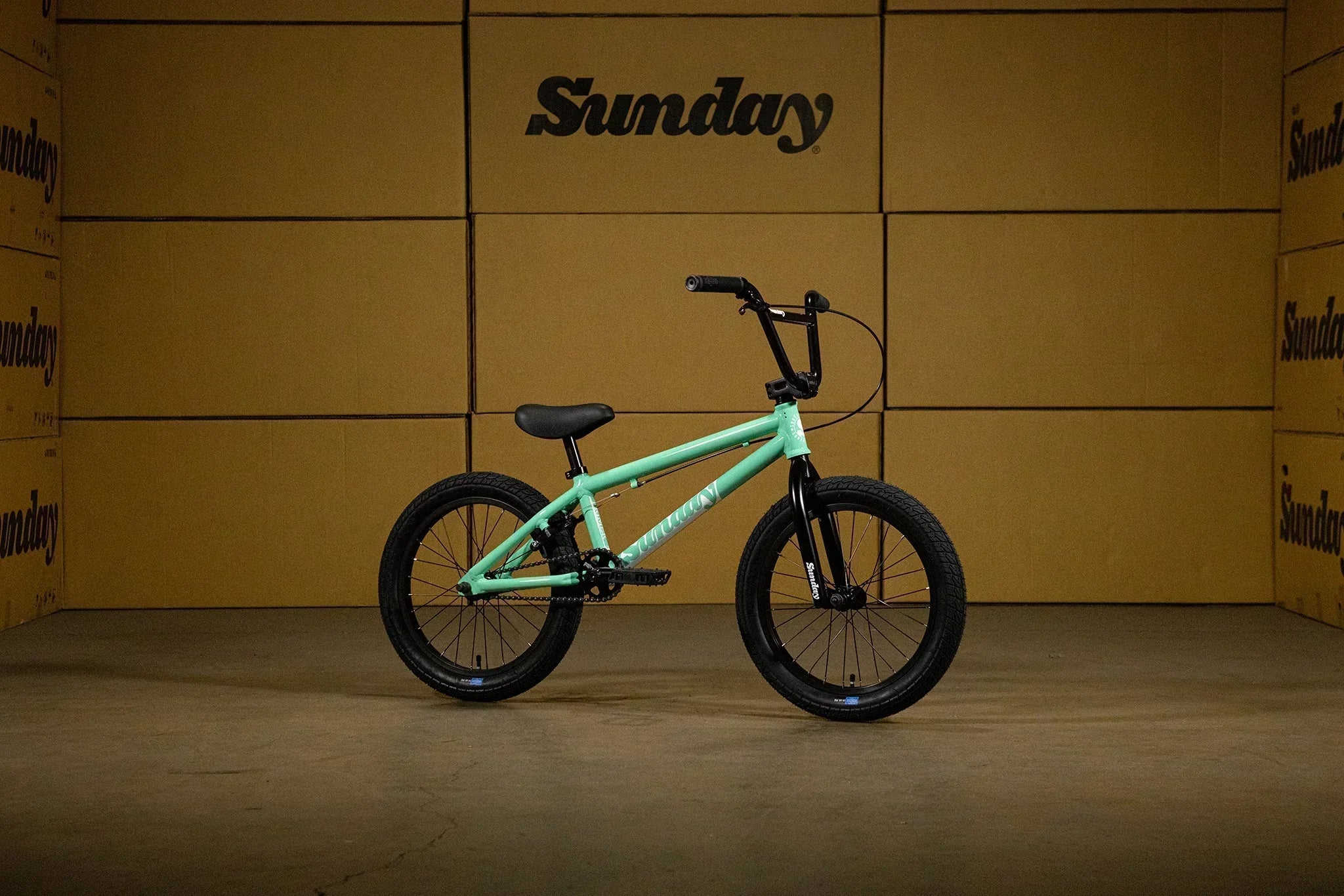 Vélo BMX Sunday vert menthe sur fond de cartons bruns