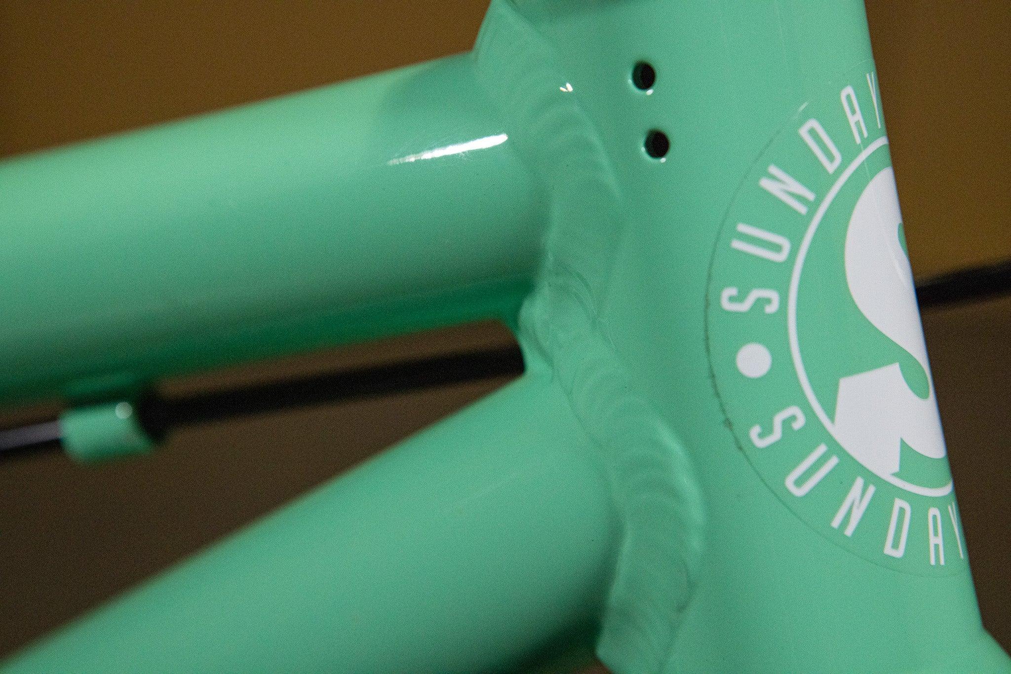 Gros plan du cadre de vélo BMX vert menthe avec logo Sunday