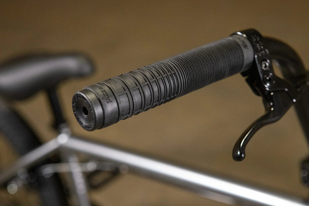 Gros plan d'une poignée de guidon noire texturée pour vélo BMX avec levier de frein.