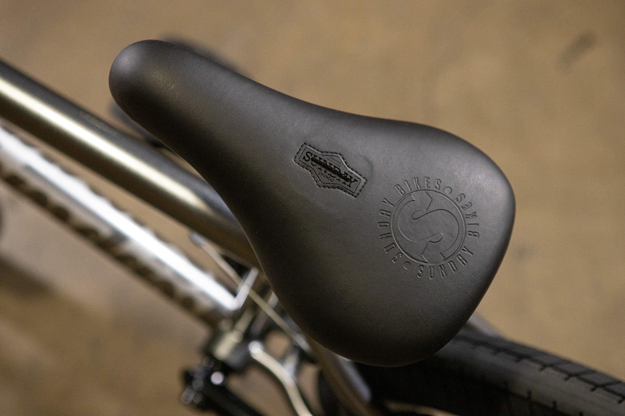 Gros plan d'une selle de vélo BMX noire Sunday avec logo embossé