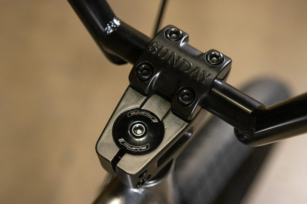 Gros plan d'une potence de vélo BMX noire de marque Sunday