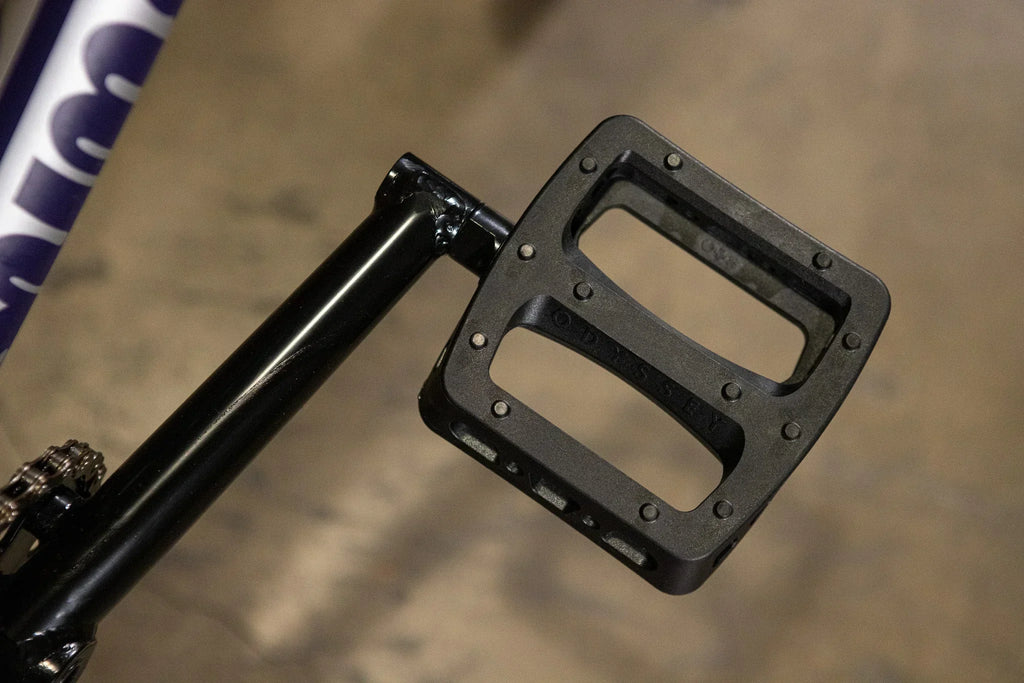 Pédale de BMX Odyssey noire fixée à une manivelle noire
