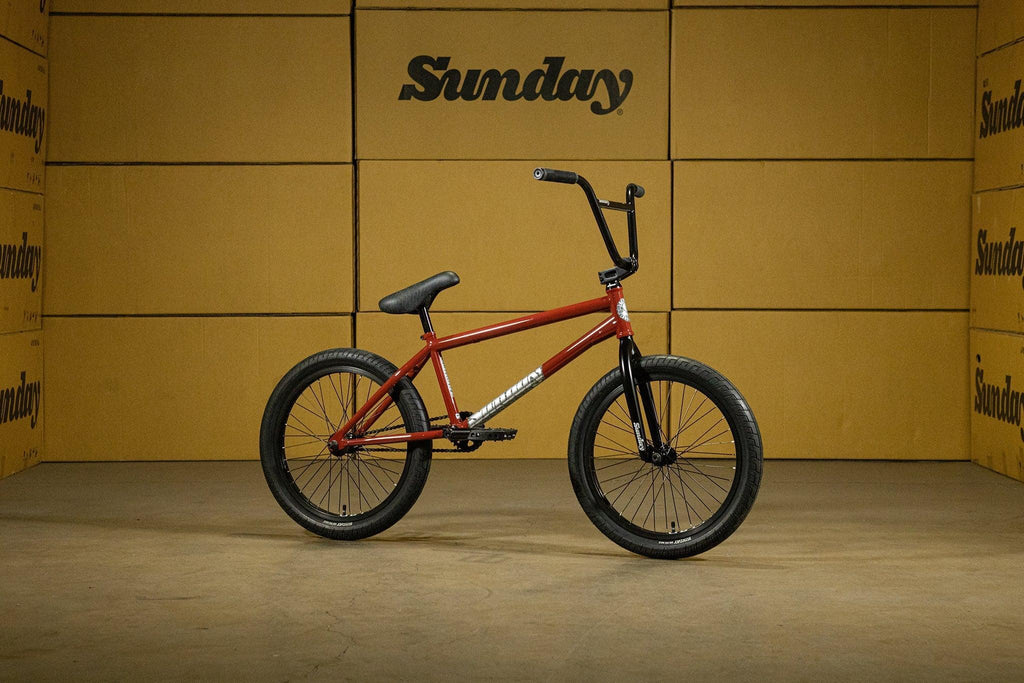 Vélo BMX Sunday rouge sur fond de cartons marron