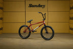Vélo BMX Sunday rouge sur fond de cartons marron