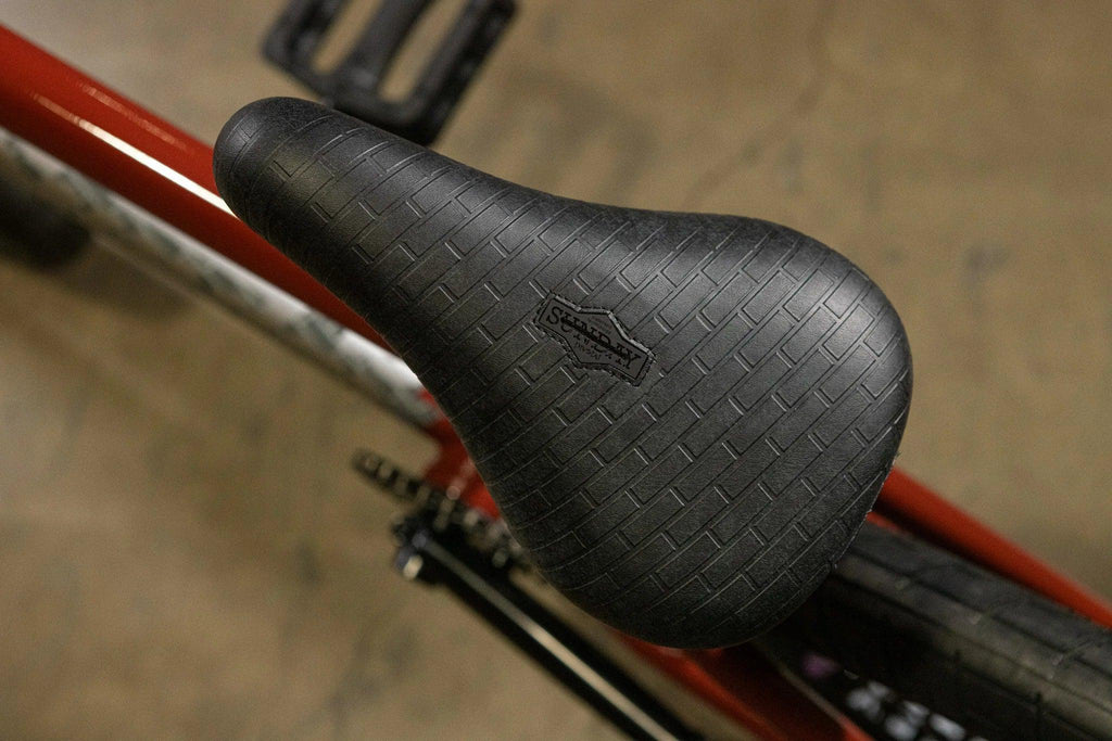 Selle de vélo BMX noire texturée avec logo Sunday sur cadre rouge