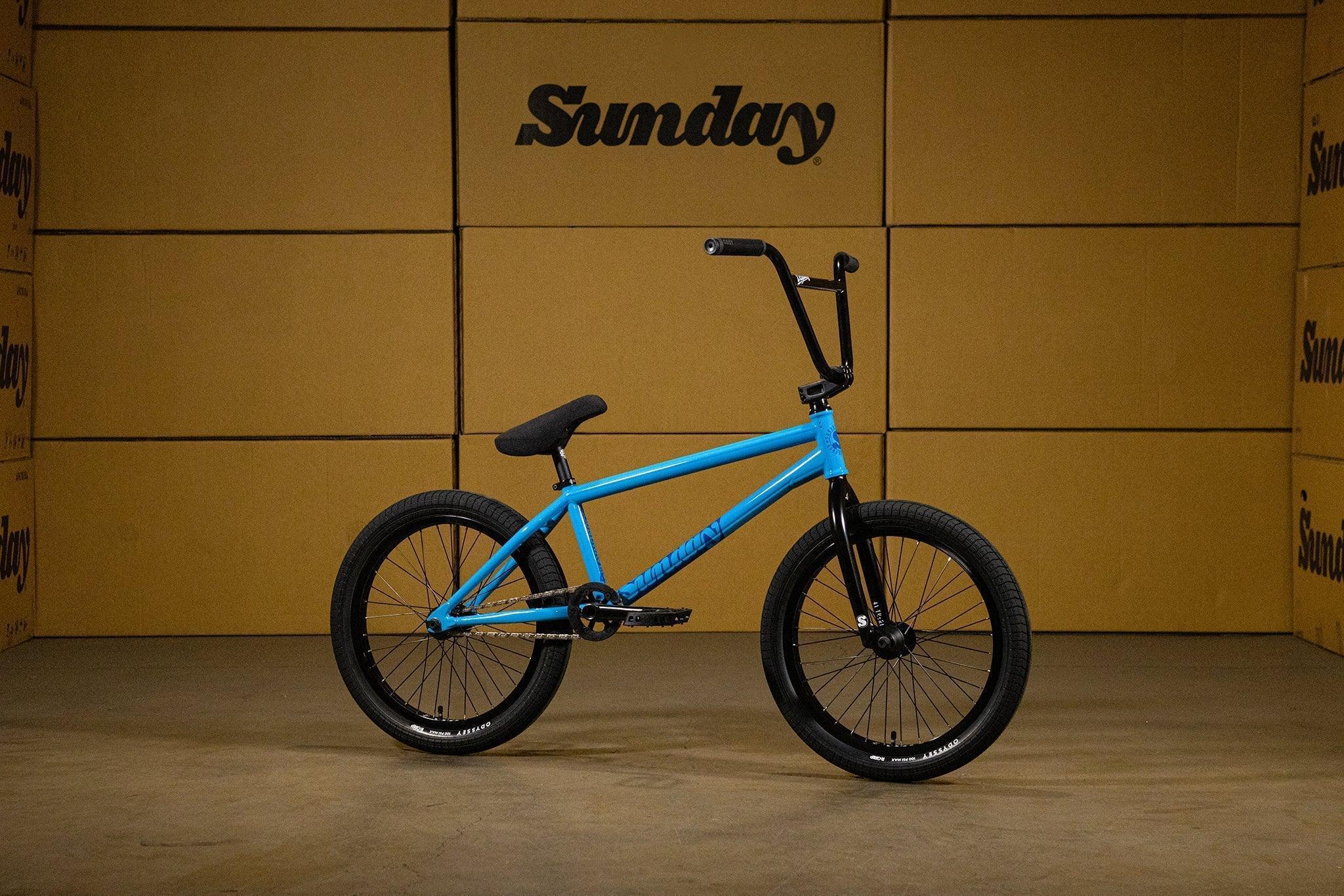 Vélo BMX bleu Sunday avec cadre bleu vif et pneus noirs sur fond de cartons