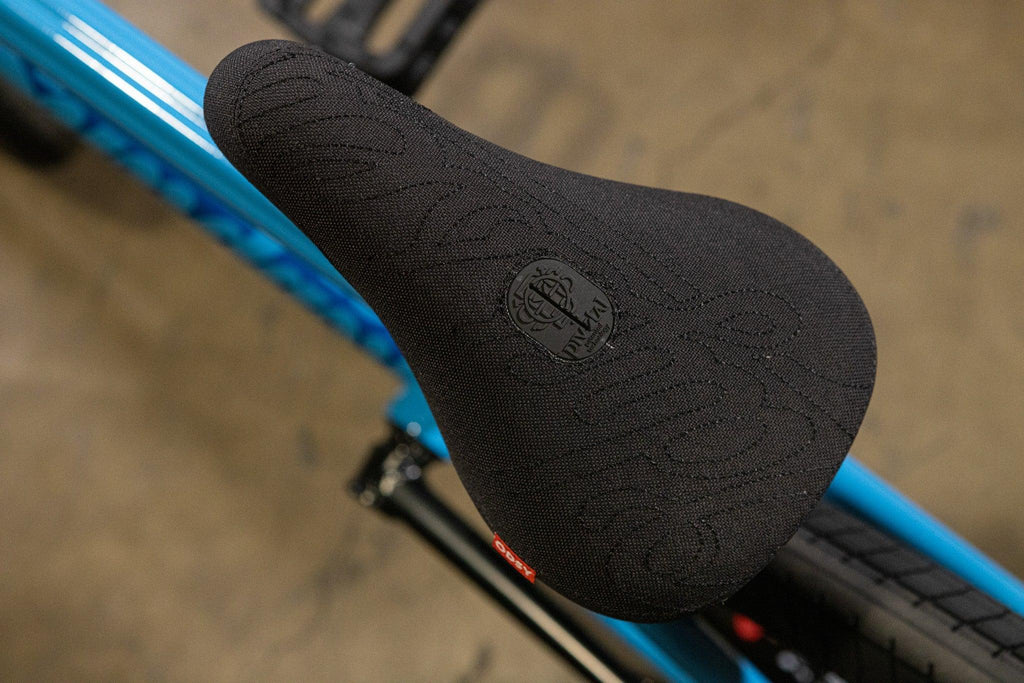 Selle de vélo BMX noire avec motif texturé sur un cadre bleu
