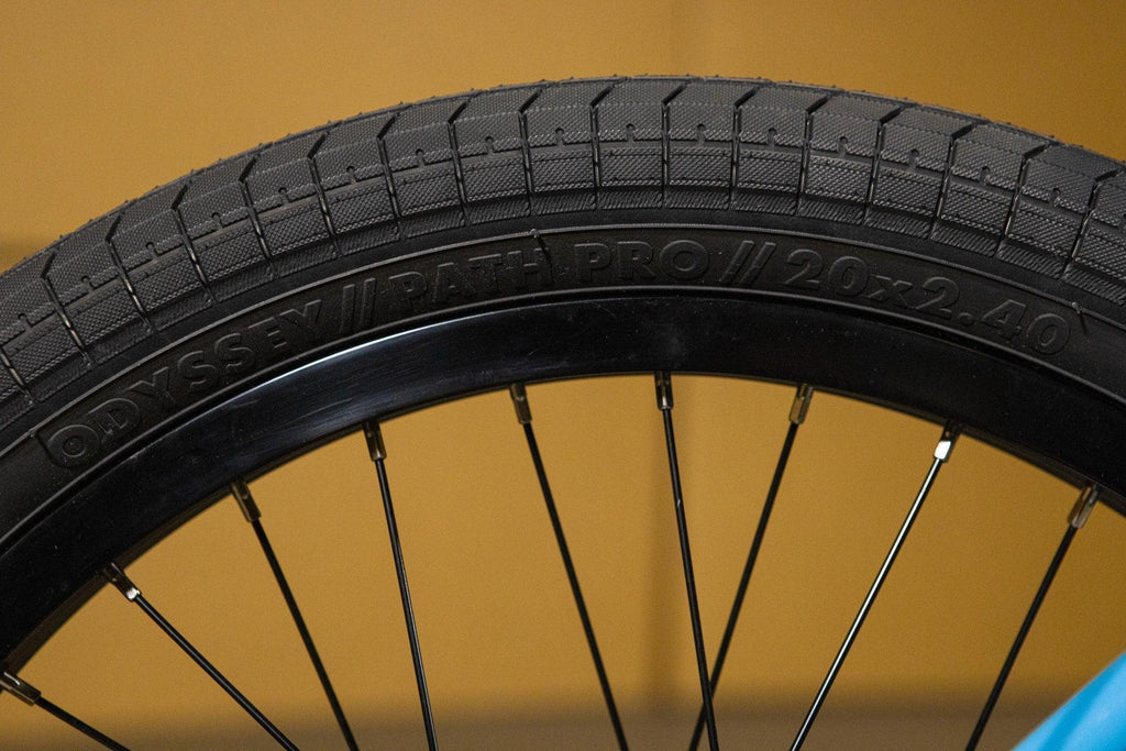 Gros plan d'un pneu BMX Odyssey Path Pro 20x2.40 noir sur jante