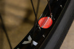 Gros plan d'une jante de vélo noire avec un autocollant rouge Hazard Lite.