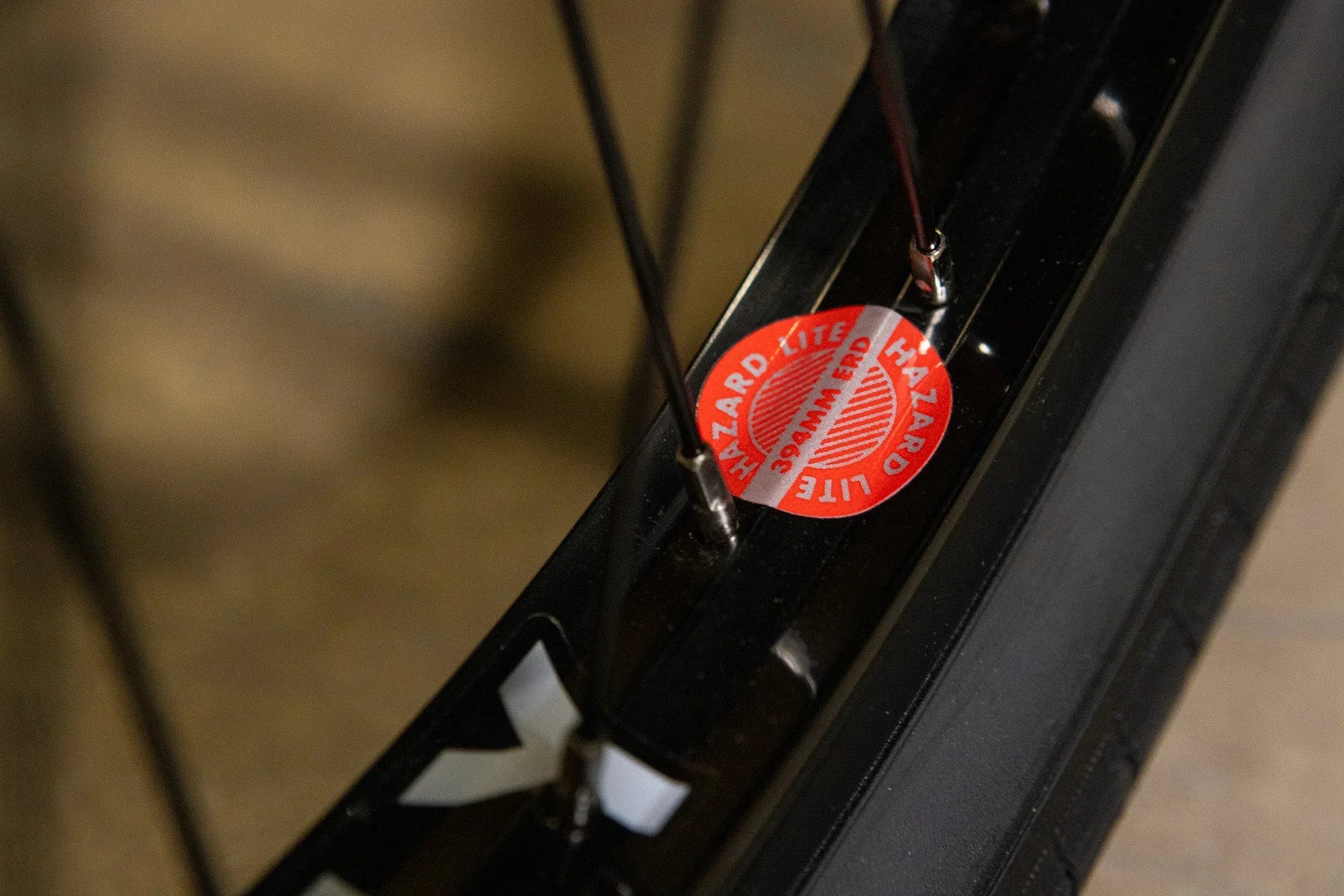 Gros plan d'une jante de vélo noire avec un autocollant rouge Hazard Lite.