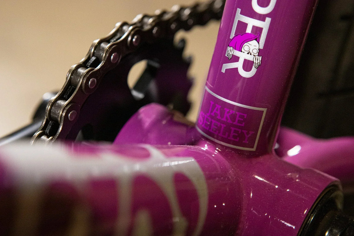 Gros plan d'un cadre de vélo BMX violet avec chaîne et plateau