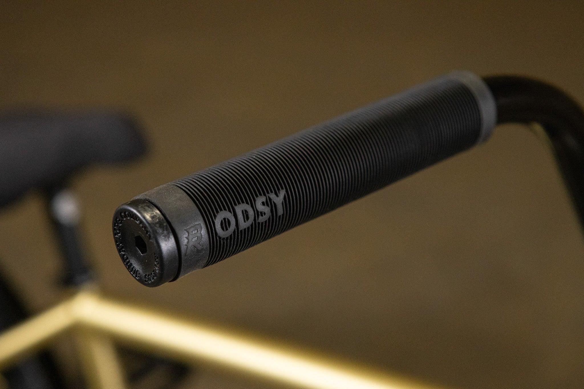 Gros plan d'une poignée de guidon BMX noire texturée de marque Odysy