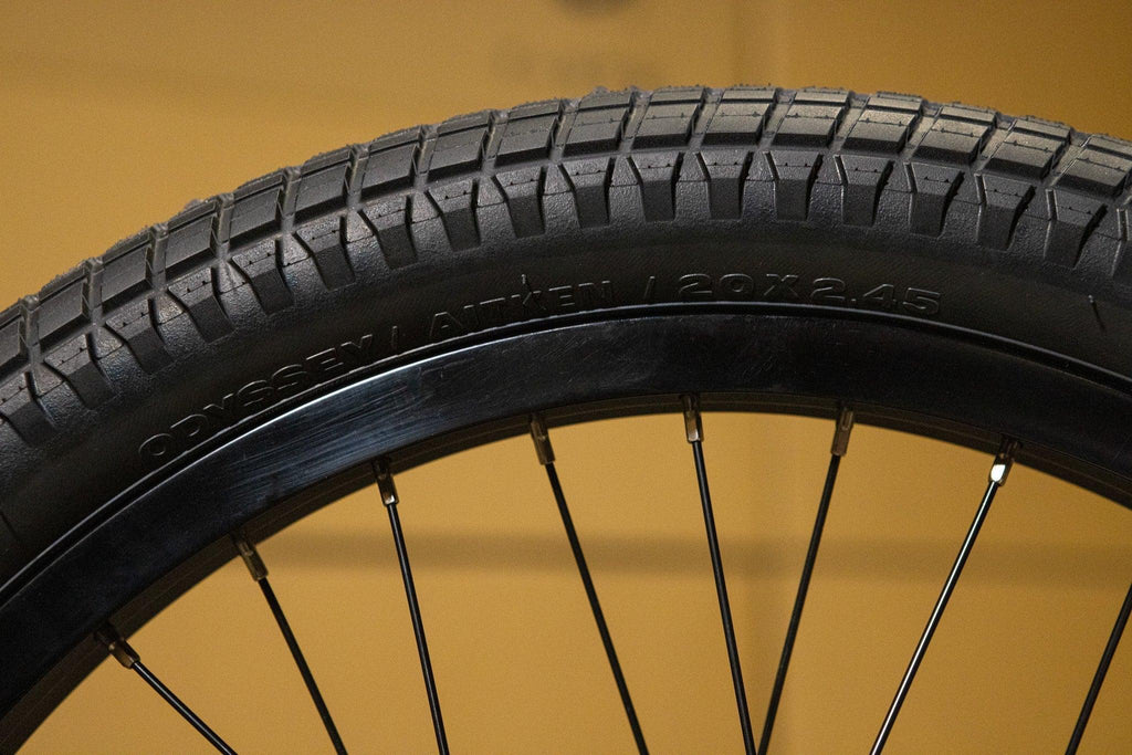 Gros plan d'un pneu de BMX Odyssey Aitken 20x2.45 avec sculptures crantées