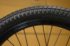 Gros plan d'un pneu de BMX Odyssey Aitken 20x2.45 avec sculptures crantées