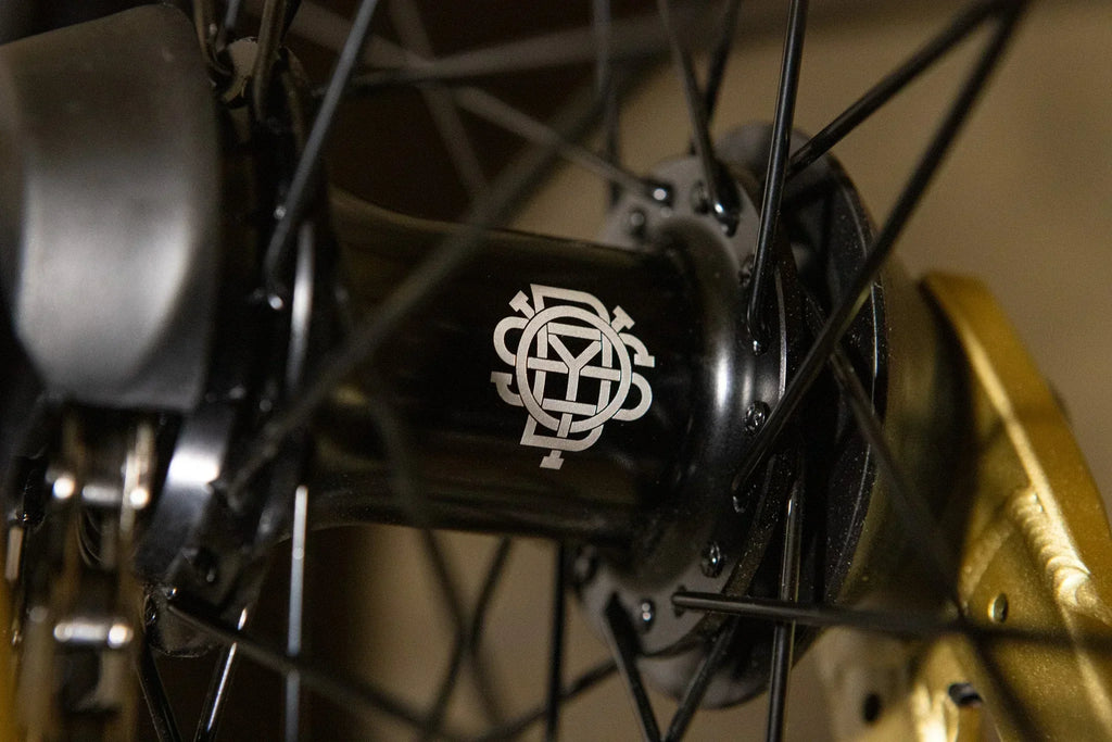 Gros plan du moyeu de roue BMX noir avec logo blanc gravé
