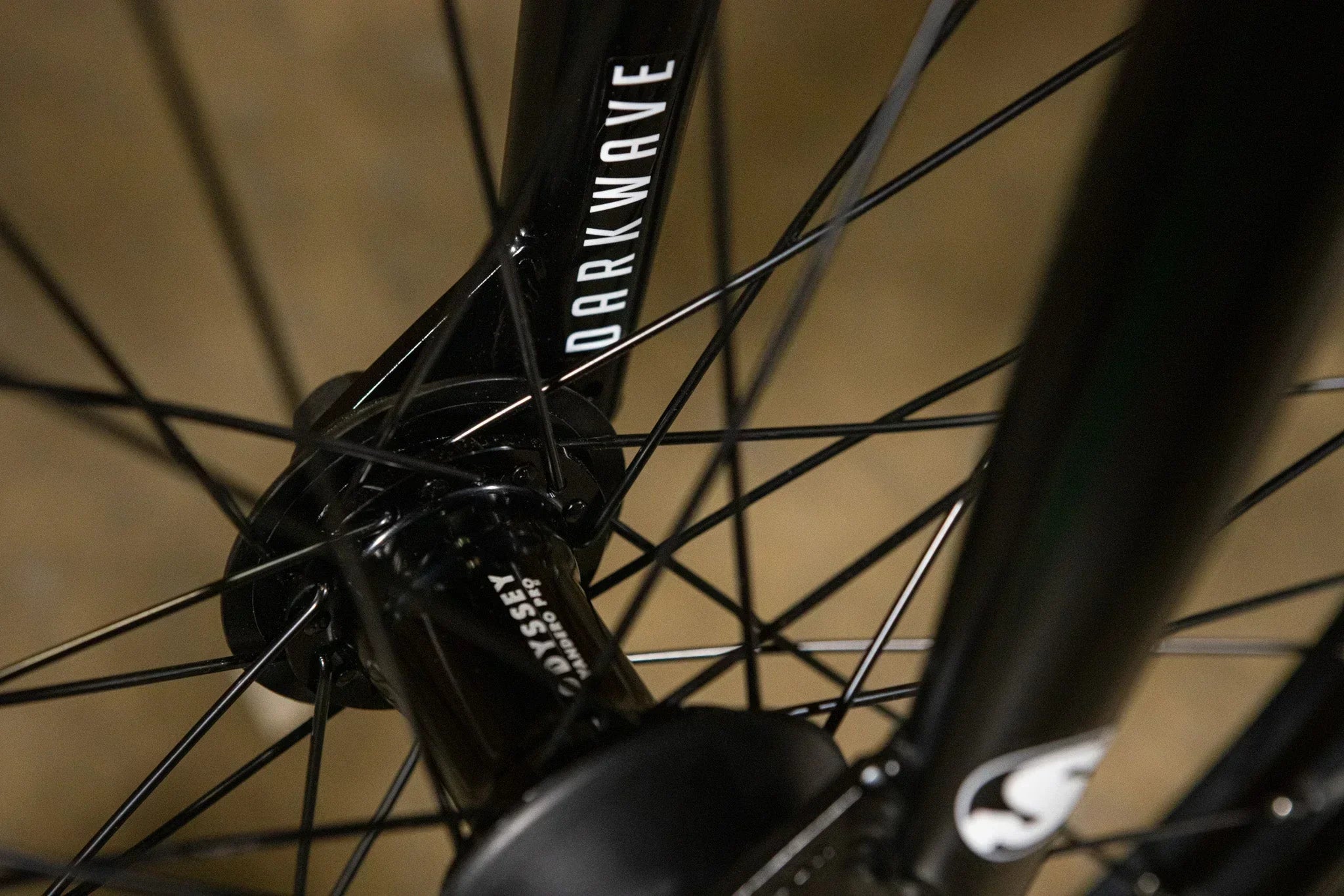 Gros plan d'un moyeu Odyssey Tandero Pro et d'une fourche Darkwave sur un vélo BMX noir.