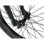 Détail de fourche et roue BMX noire avec logo turquoise, composants robustes pour vélo de freestyle