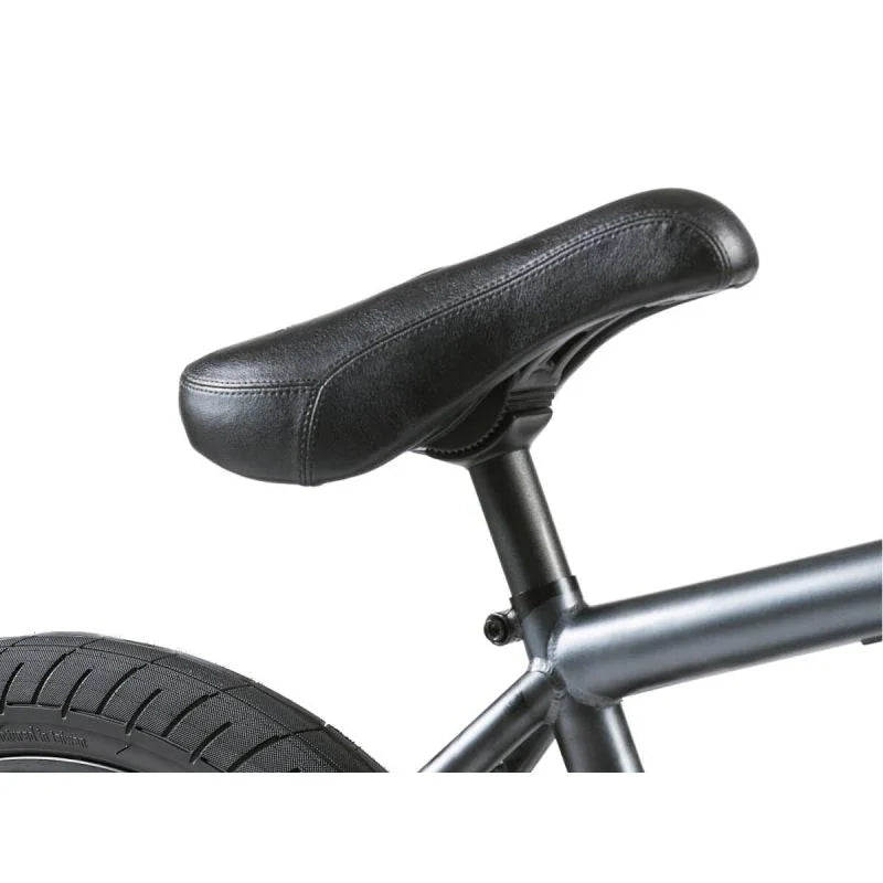 Selle BMX noire en cuir synthétique sur cadre métallique, vue rapprochée