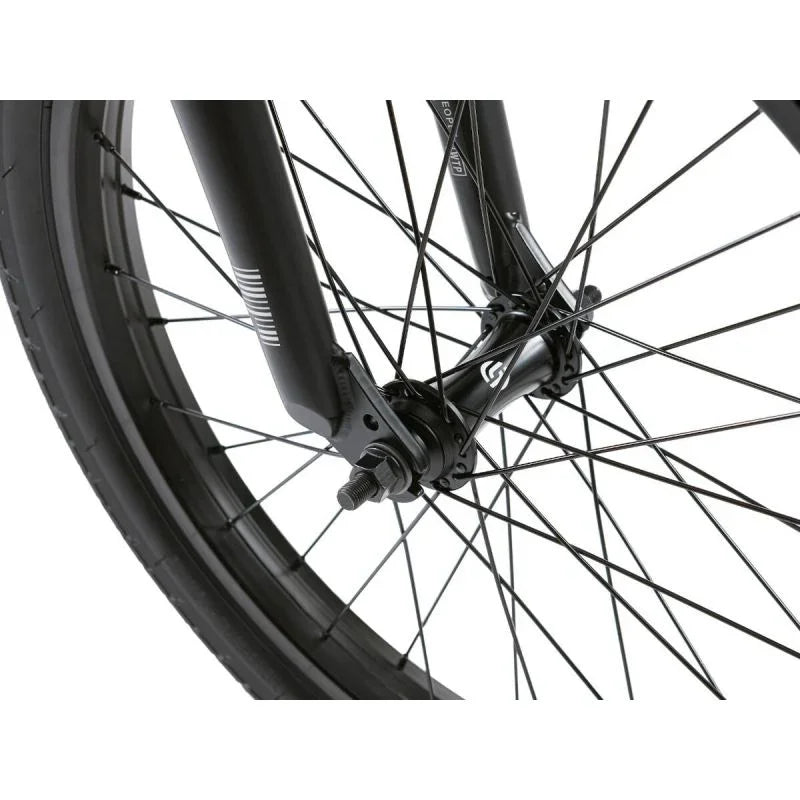Détail de la fourche et de la roue avant d'un vélo BMX noir, avec rayons et moyeu robustes
