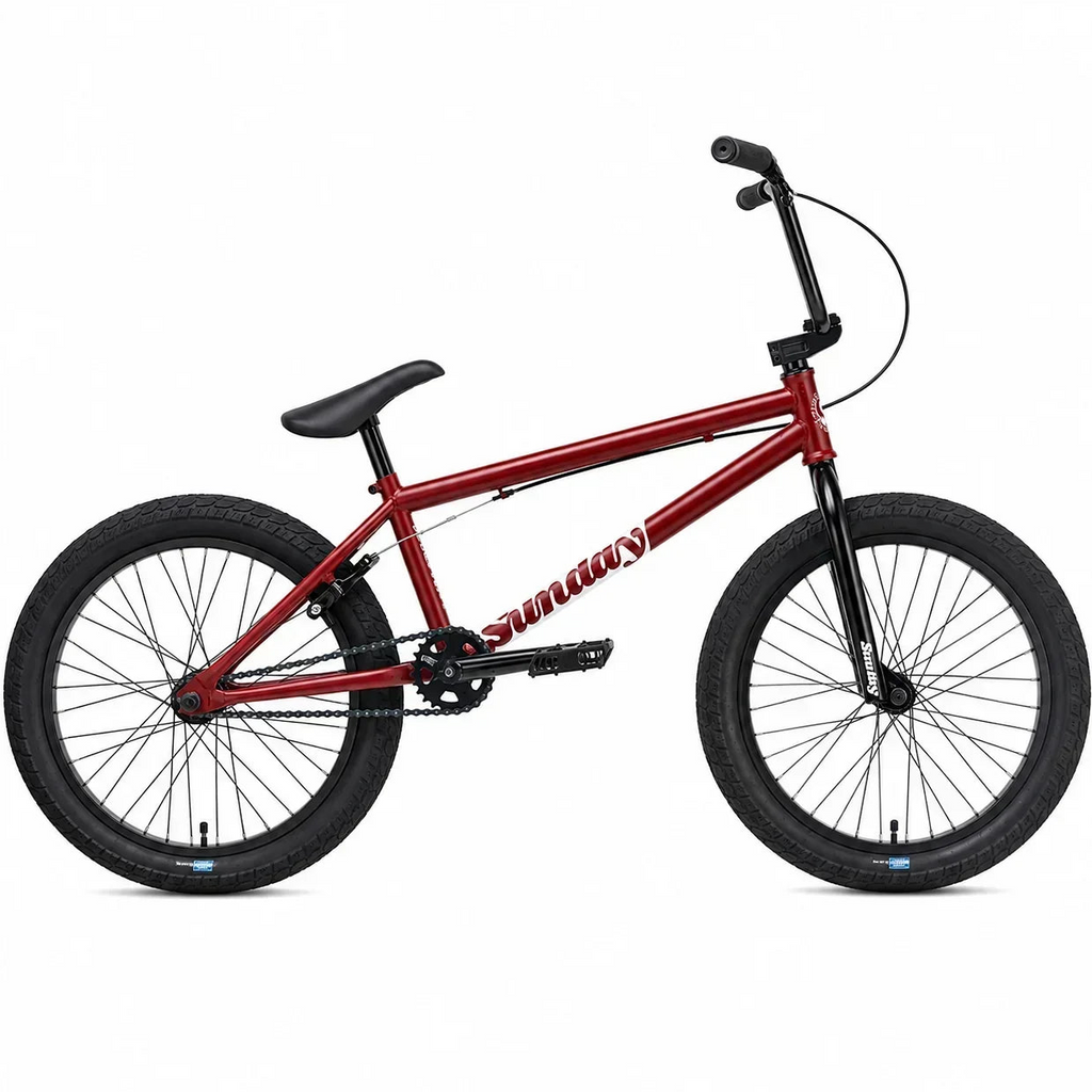 Vélo BMX Sunday rouge avec cadre métallique, pneus noirs et guidon relevé sur fond blanc.