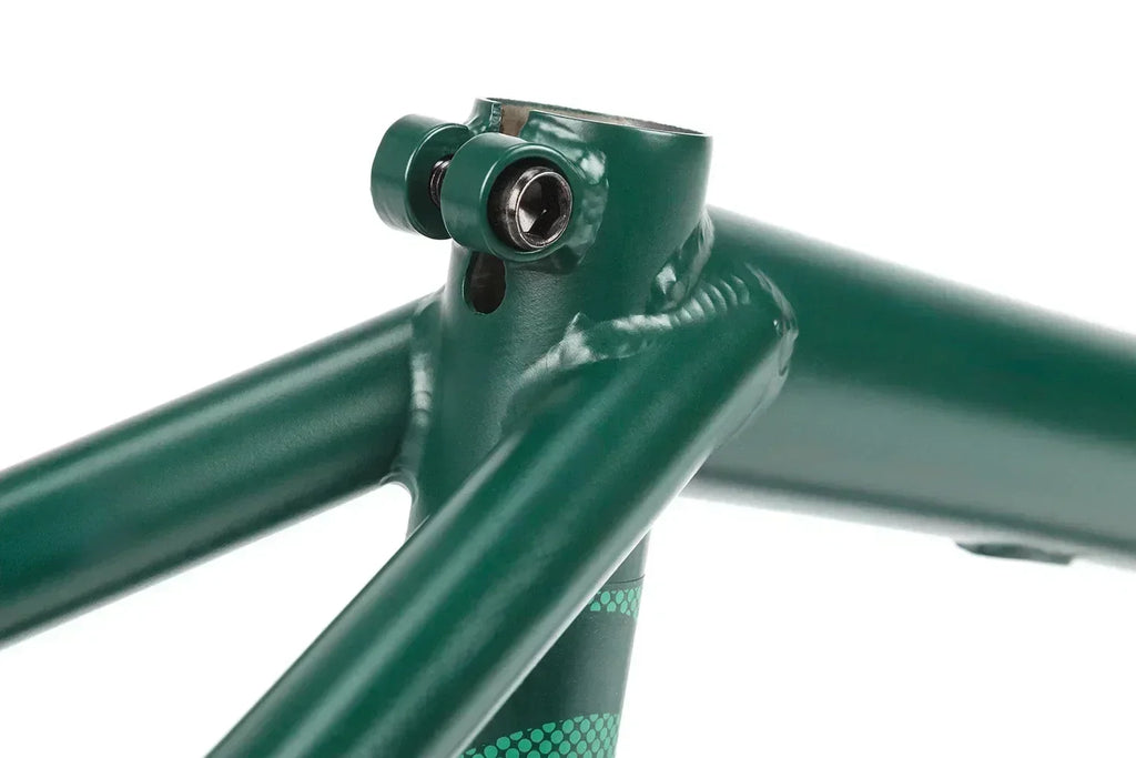 Détail du cadre de BMX vert foncé avec vis de fixation au niveau de la douille de direction.