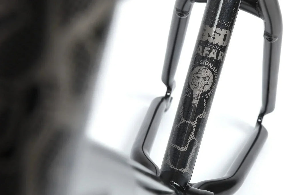 Détail de la fourche de BMX noire avec motif serpent et logo signature.