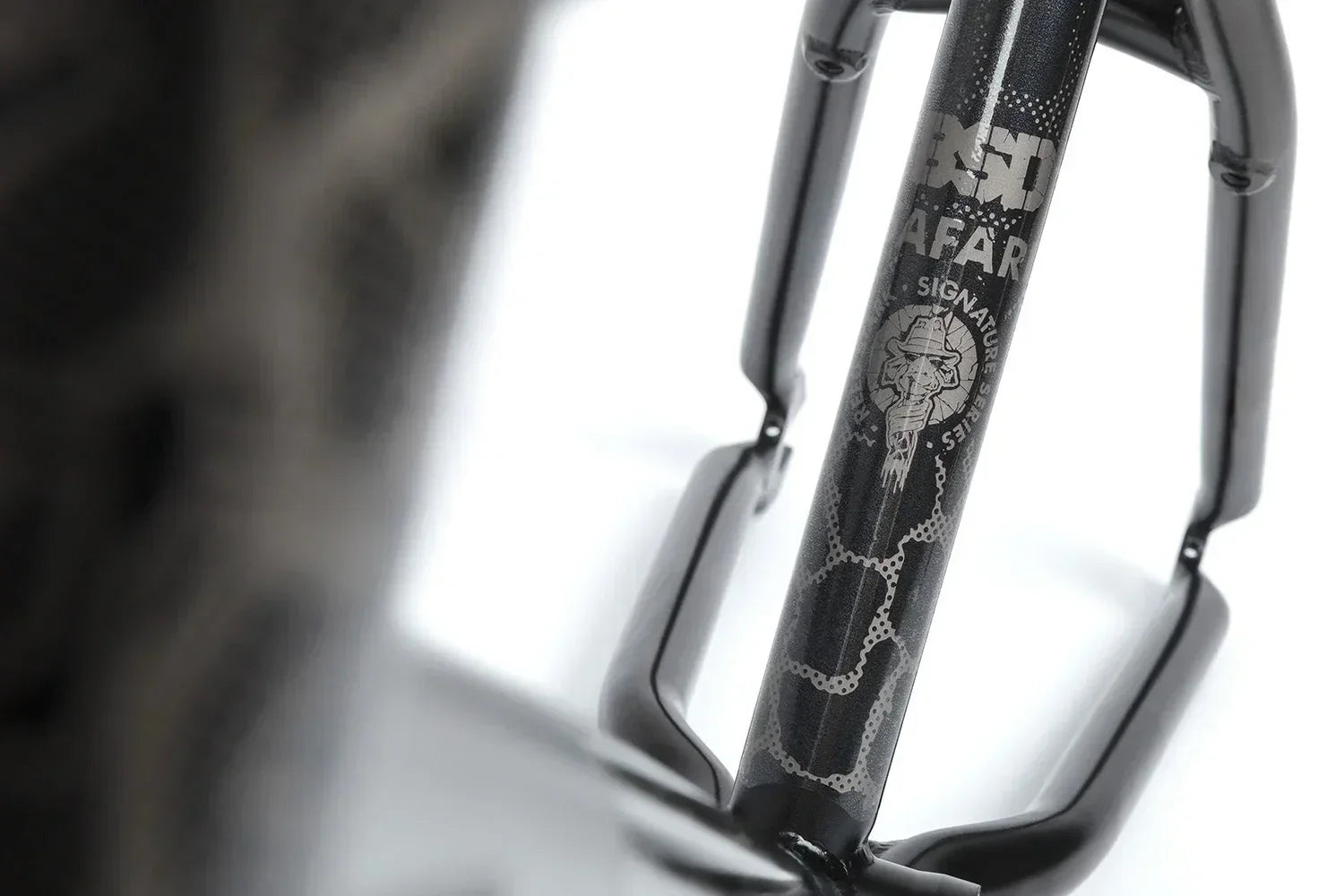 Détail de la fourche de BMX noire avec motif serpent et logo signature.