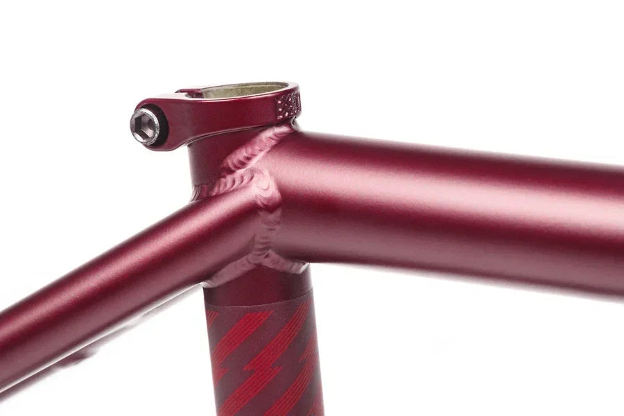 Cadre de BMX rouge métallisé avec détails de soudure et potence de direction.
